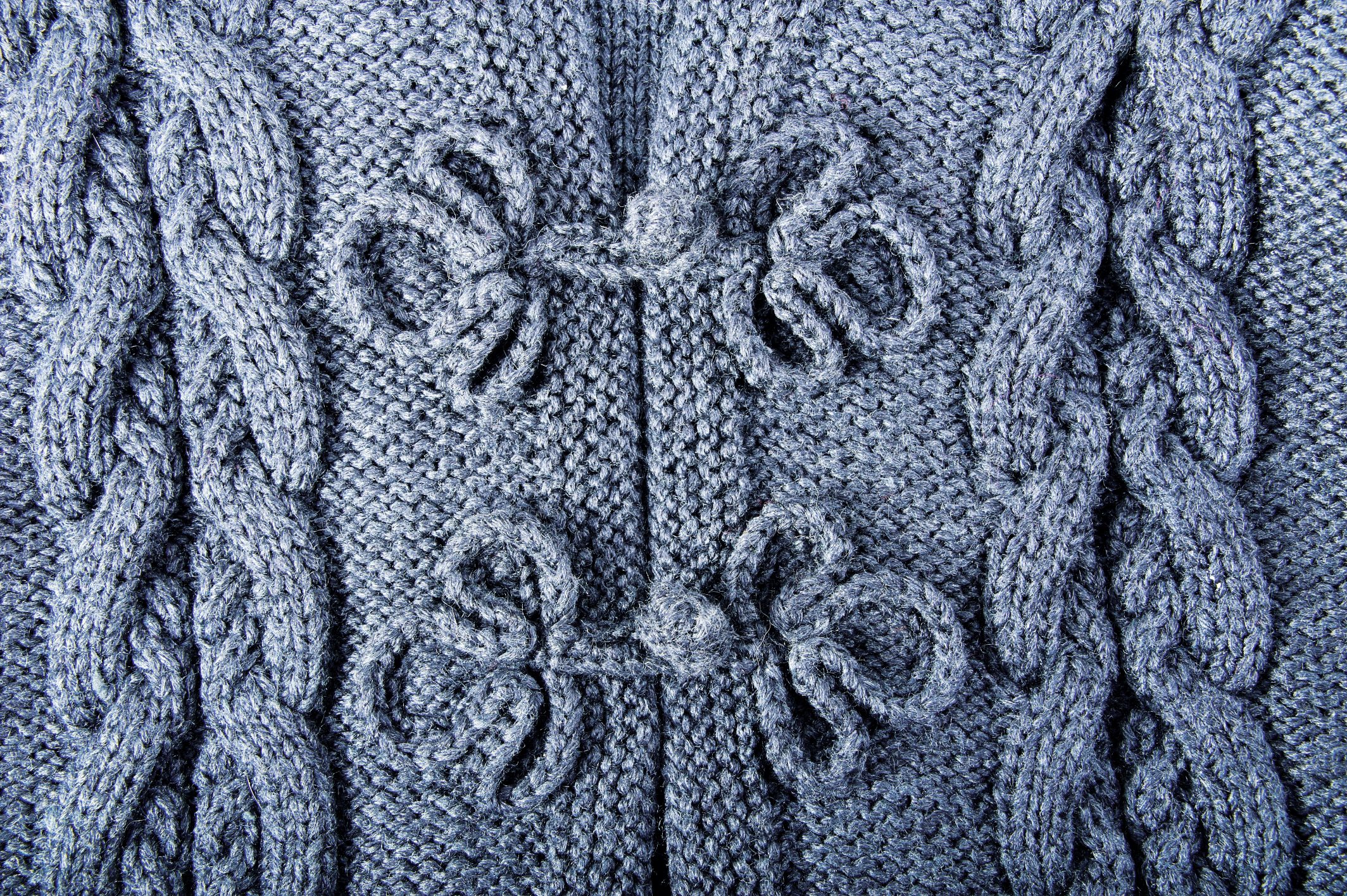 Graue Strickjacke mit handgemachten Zopfmustern, filigrane Schleifendetails, modisch und zeitlos.