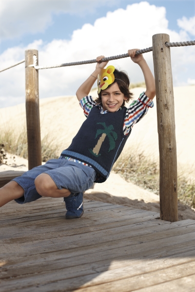 Bunter Strickpullover mit Palmenmuster; stilvolle Streifenhemd-Ärmel; modische Jeansshorts in Blau.