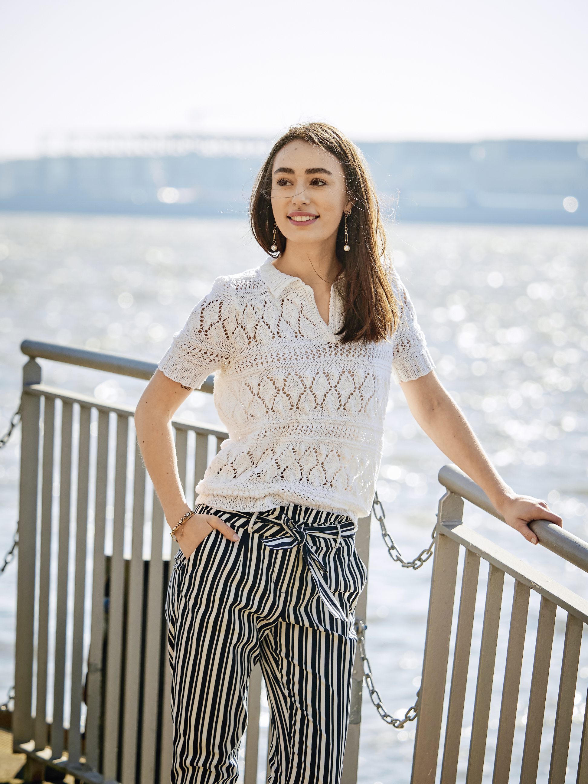 Weißer Strickpullover, selbstgemacht, kombiniert mit modischer, gestreifter Hose, lässiger Schnitt.