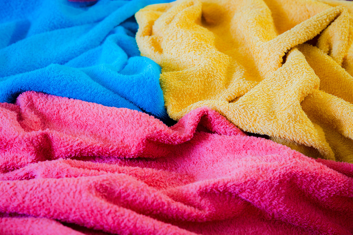 Leuchtende Farben in Blau, Gelb, Pink; flauschige, strukturierte Stoffe. Modisch, handgemacht, stilvoll.