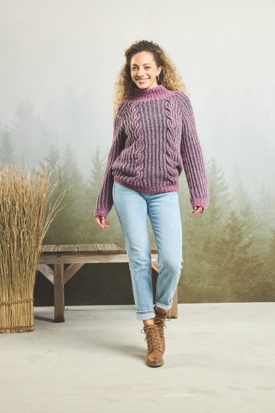 Handgemachter, lila-gestreifter Zopfpullover, lässige Jeans, braune Boots. DIY-Charme.