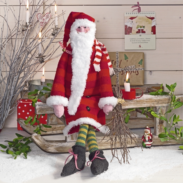 Handgemachte Santa-Puppe in rotem Anzug, flauschigem Weiß, gestreiften Socken. Modisches DIY-Design.