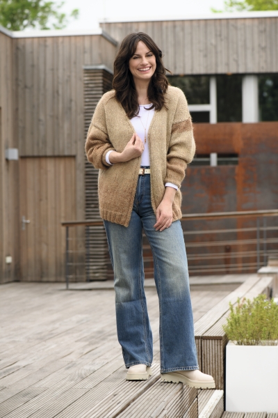 Grobe, beige Strickjacke, moderne Schlagjeans in Dunkelblau, lässig-modisch, handgemacht wirkend.
