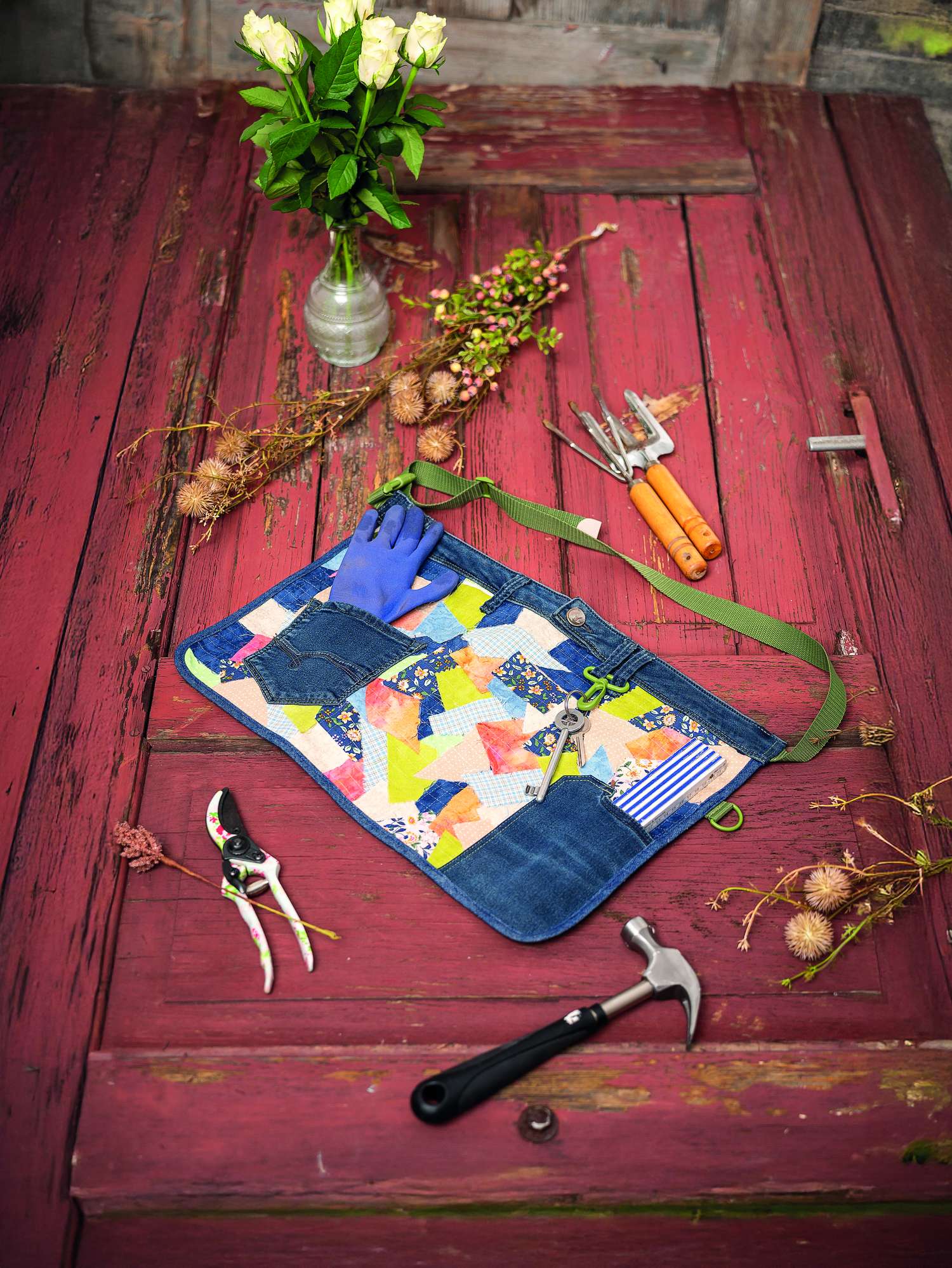 Patchwork-Schürze in lebhaften Farben, Denim-Elemente, grüne Träger; handgemacht, ideal für Gartenarbeit.