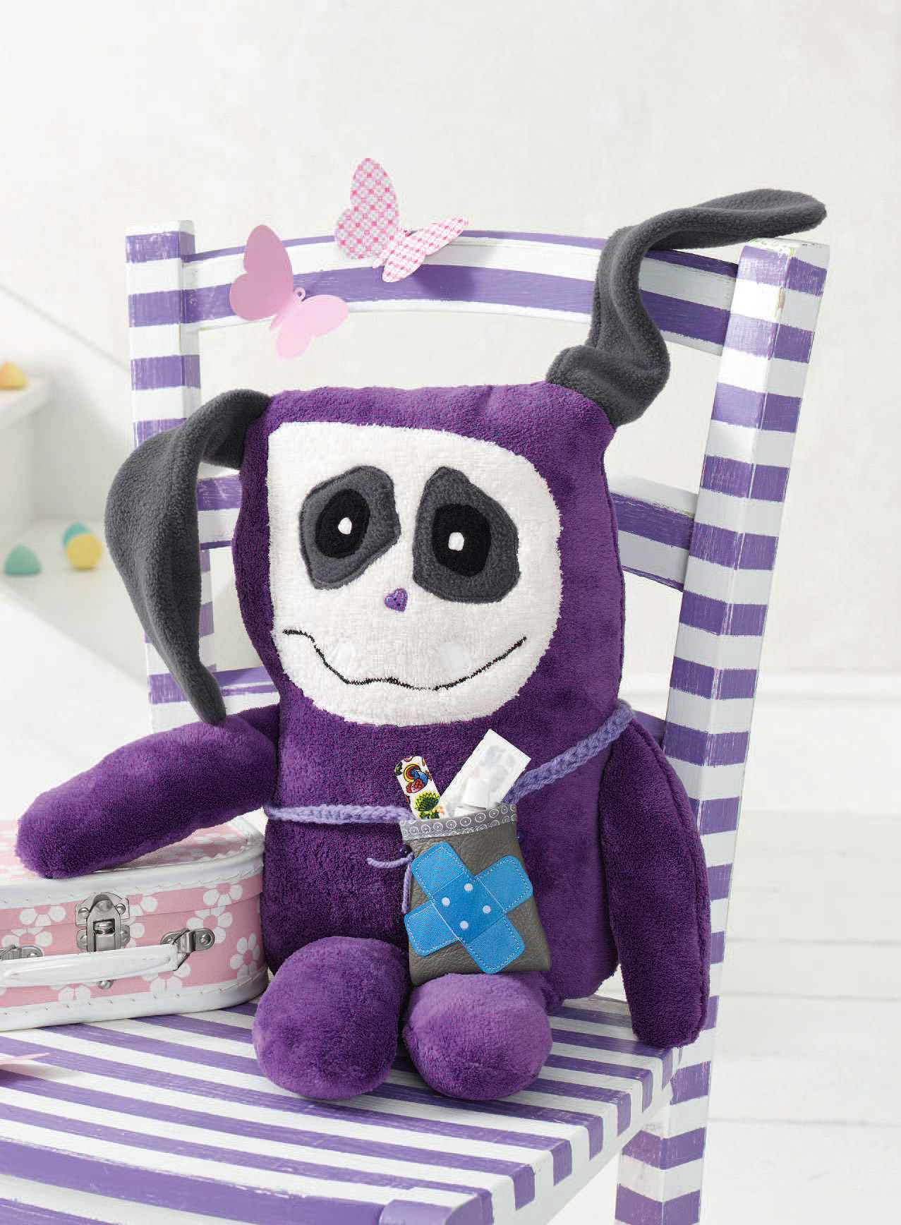 Modisches, selbstgemachtes lila Plüschspielzeug mit Gesichtsmuster. Besonderheiten: kreative Details, DIY-Style.