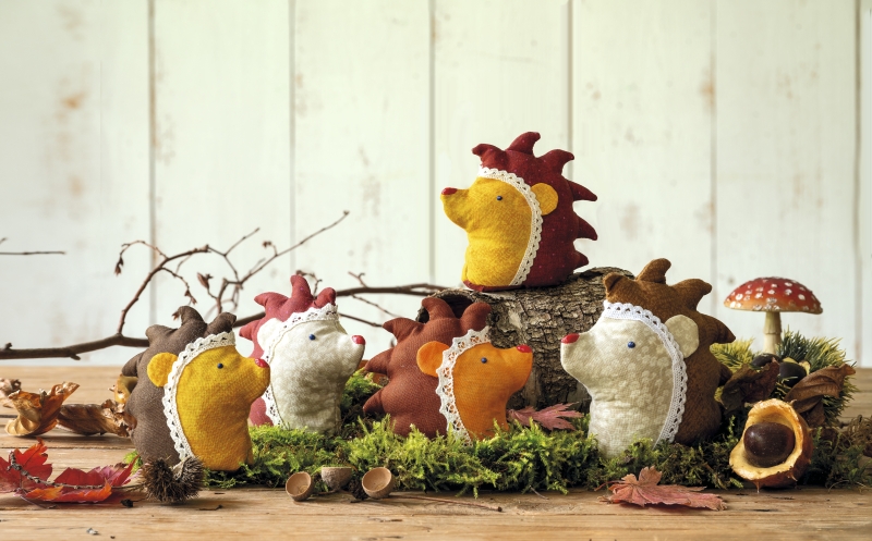 Bunte Filzigel mit Spitze; handgemacht, DIY, kunstvoll arrangiert auf Moos.