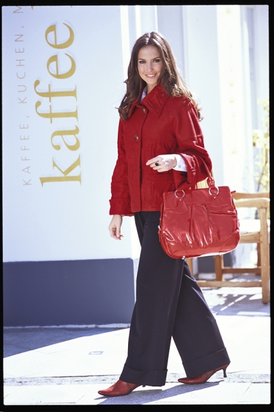Modischer roter Mantel, passende Tasche und Schuhe. Klassische weite Hose, kontrastreich und elegant.