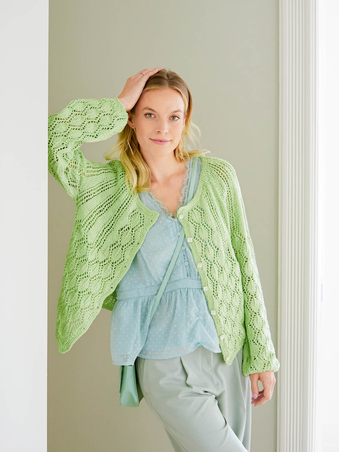 Pastellgrüner Cardigan mit Lochmuster, blaue Bluse, lockere Passform, modisch und handgemacht.