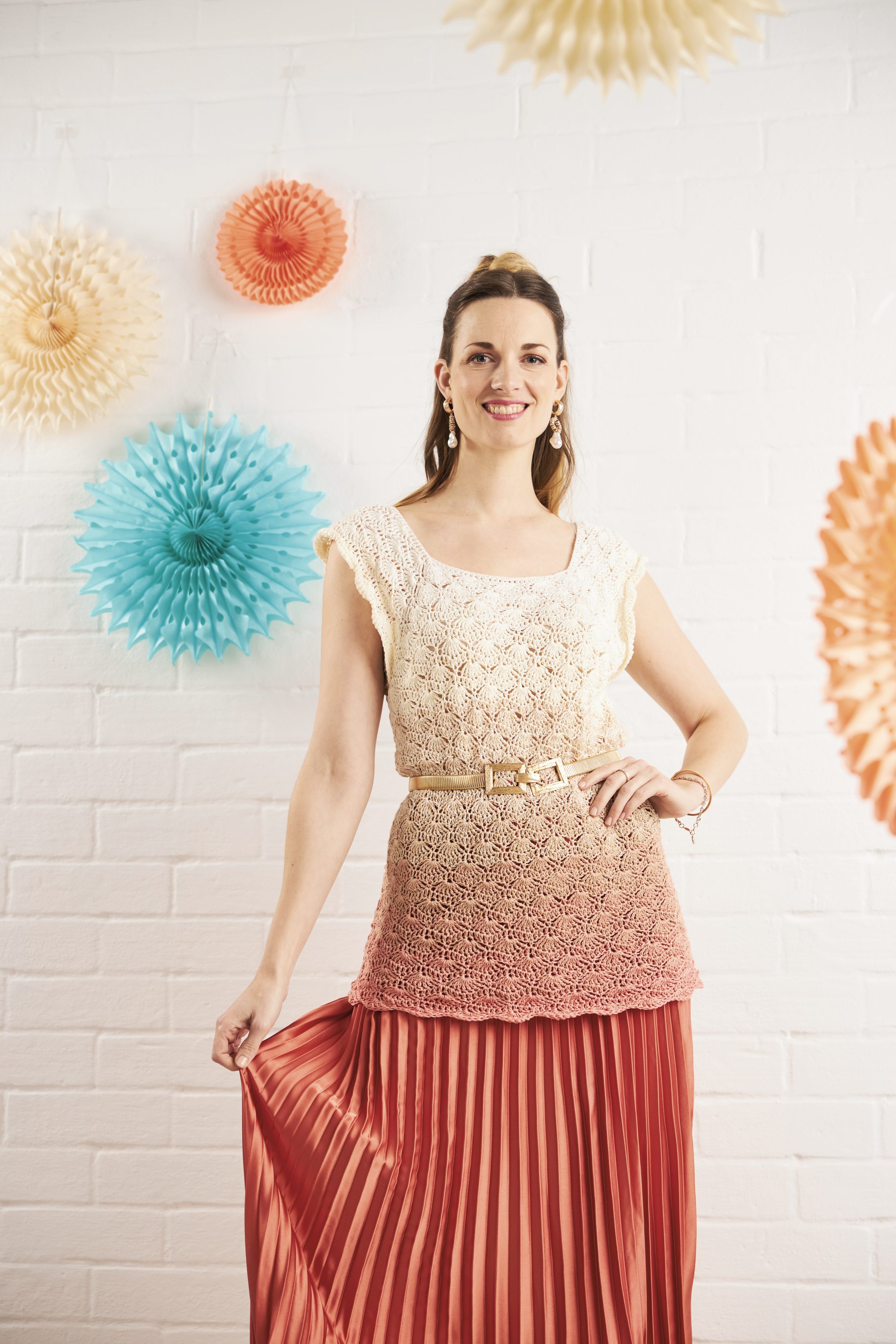 Beiges, handgemachtes Stricktop, kombiniert mit fließendem, rotem Plisseerock. Modisch und einzigartig.