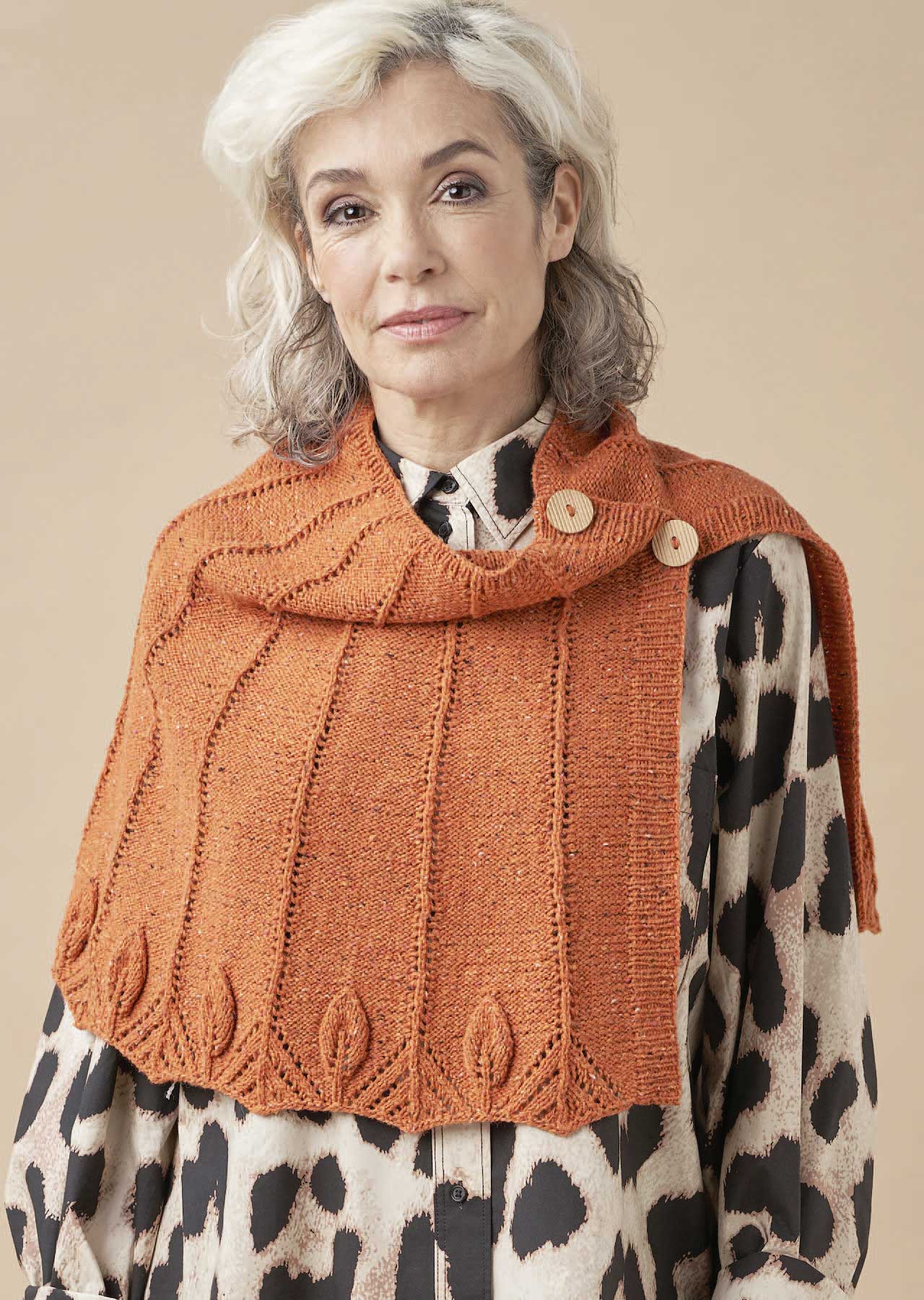 Orange, handgestricktes Tuch mit Blattmuster, Knöpfen; modische Kombination mit animal-print Bluse.
