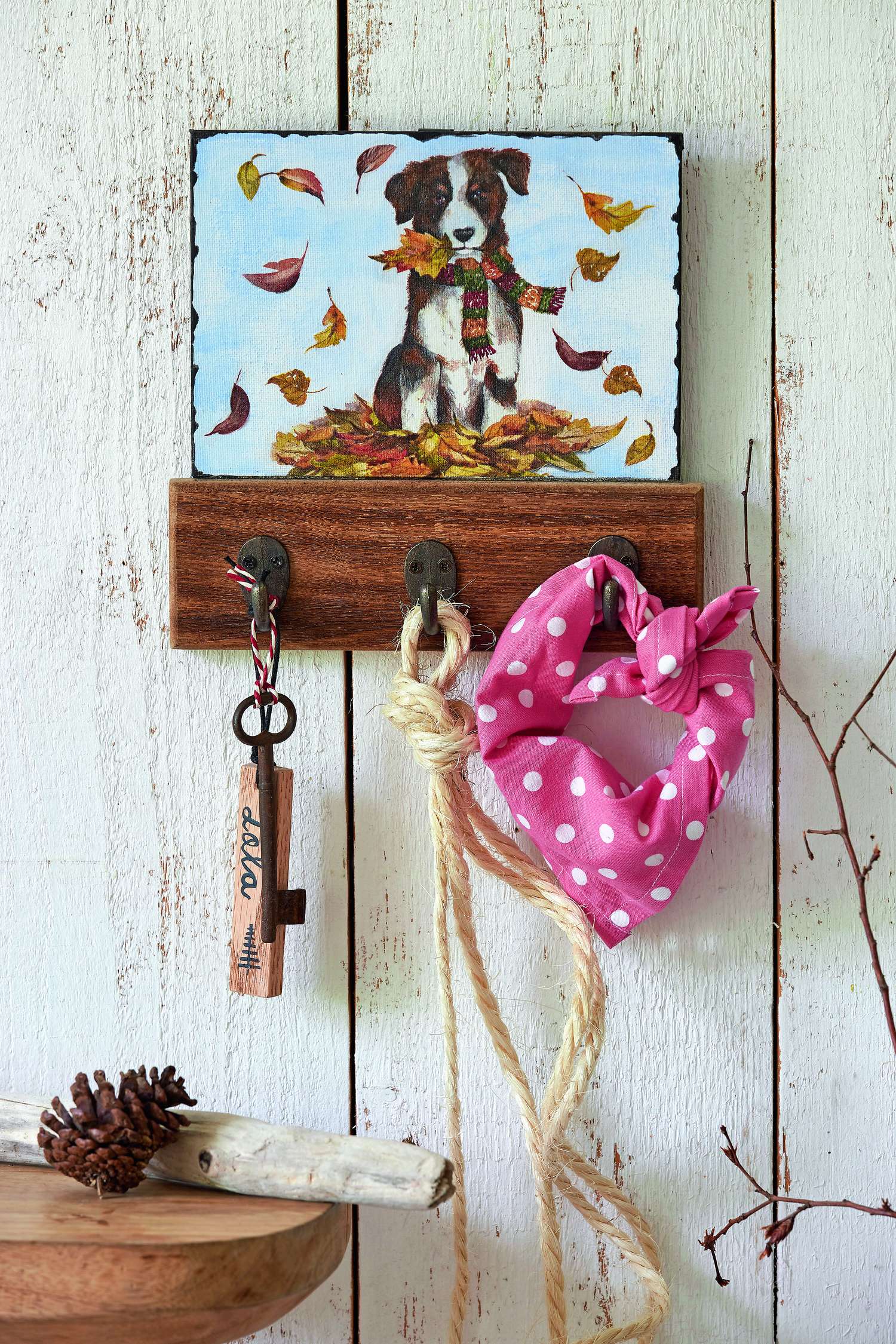 Modische rosa Schleife mit weißen Punkten an rustikalem Holzbrett. DIY-Zauber mit herbstlichem Hundemotiv.