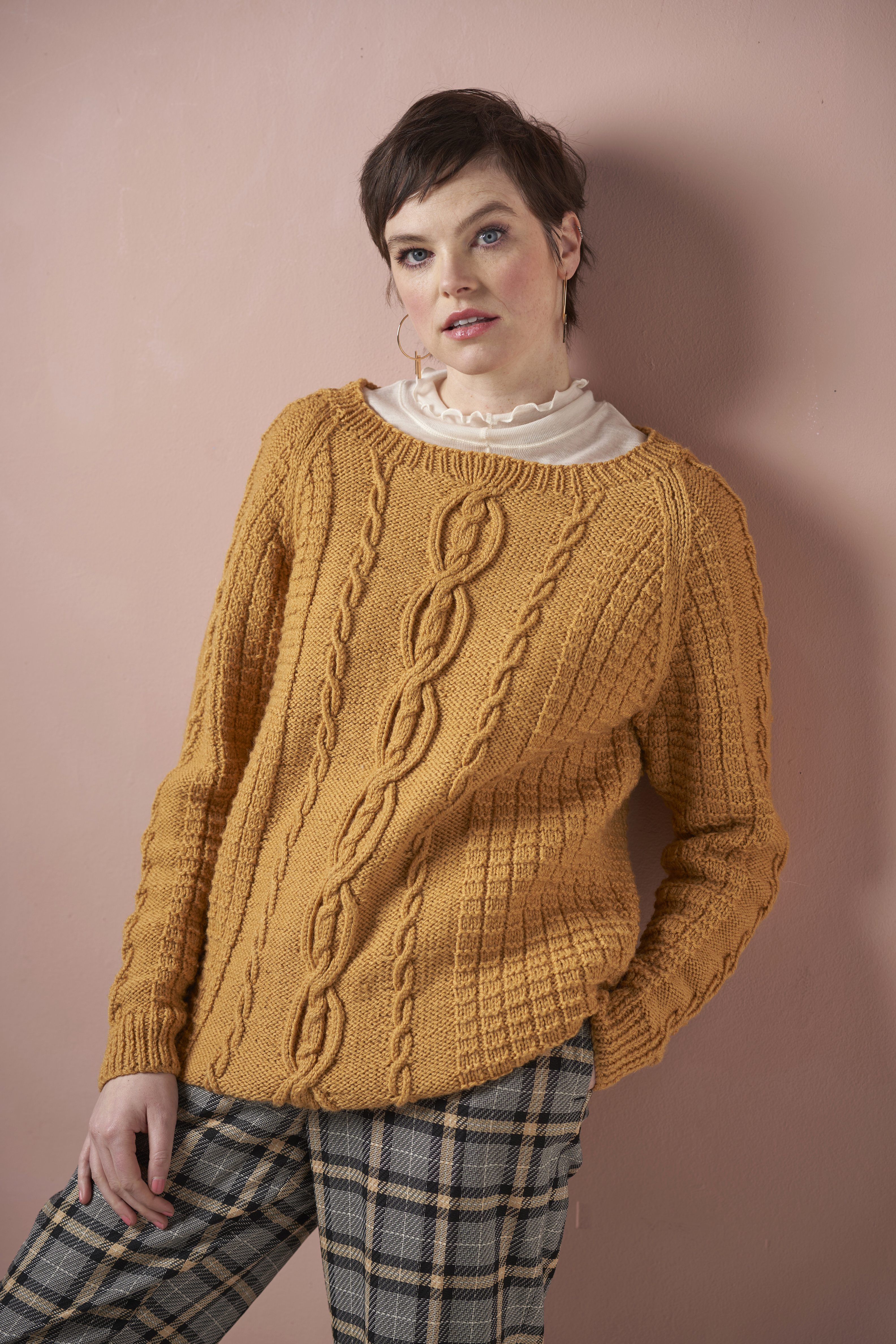 Senfgelber Zopfpullover, handgestrickt, modisch, karierte Hose, stilvoll kombiniert.