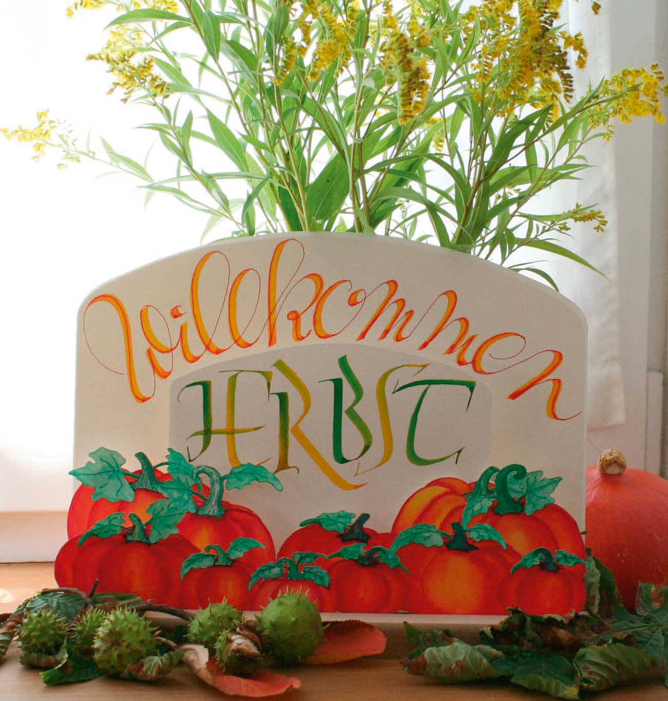 Handgemaltes Willkommensschild in warmen Herbsttönen. DIY-Design mit Kürbismotiven und kunstvoller Schrift.
