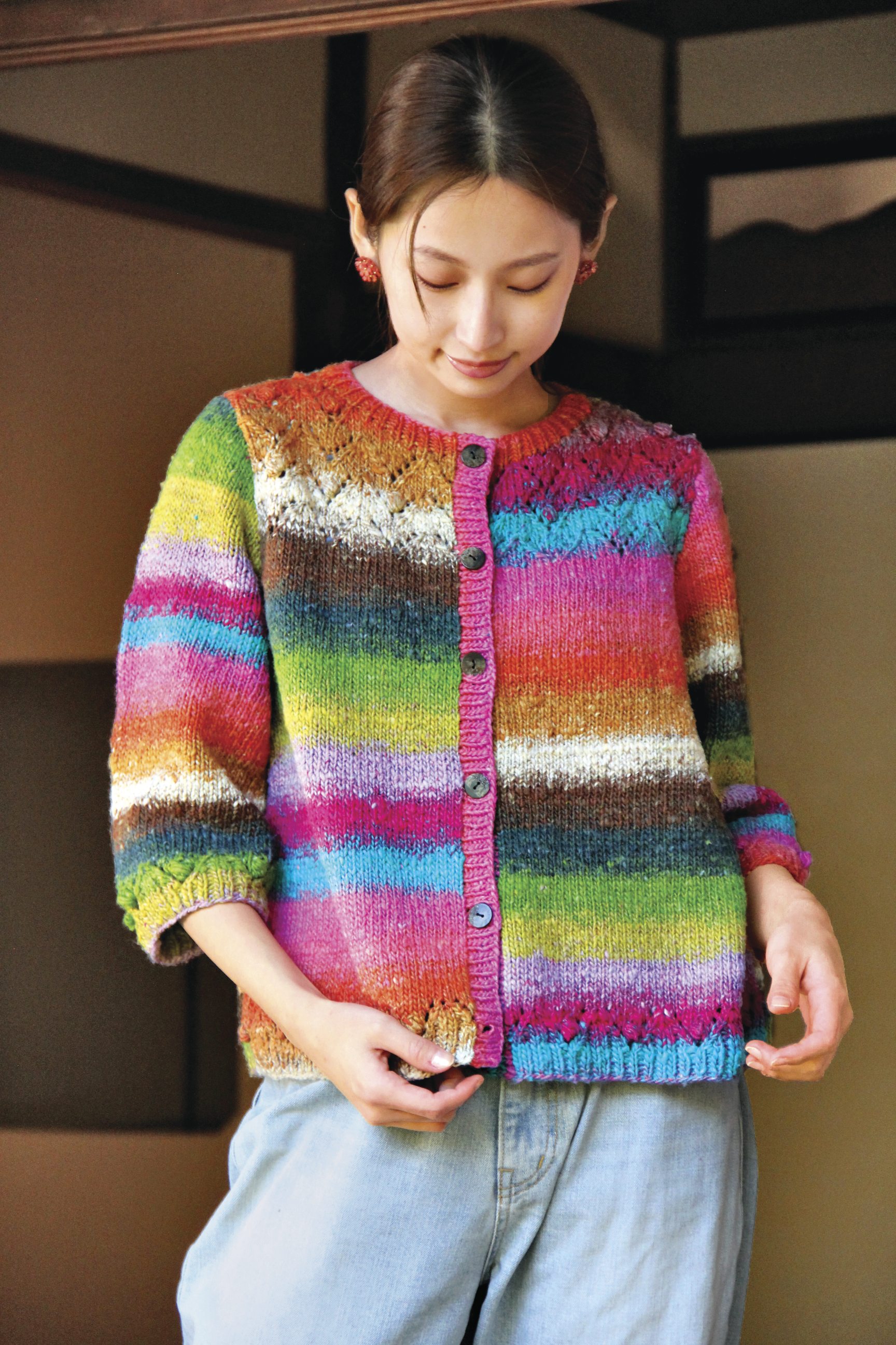 Modische, handgemachte Strickjacke mit bunten Streifen, Knopfleiste, 3/4-Ärmeln, lebendige Farben, DIY-Charme.