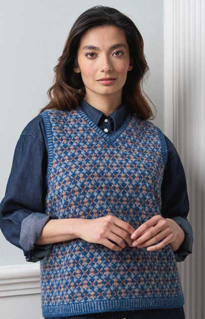Blau-gemusterter Strickweste, V-Ausschnitt, modisch, retro. Über dunkelblauer Bluse getragen, selbstgemacht, stylish.