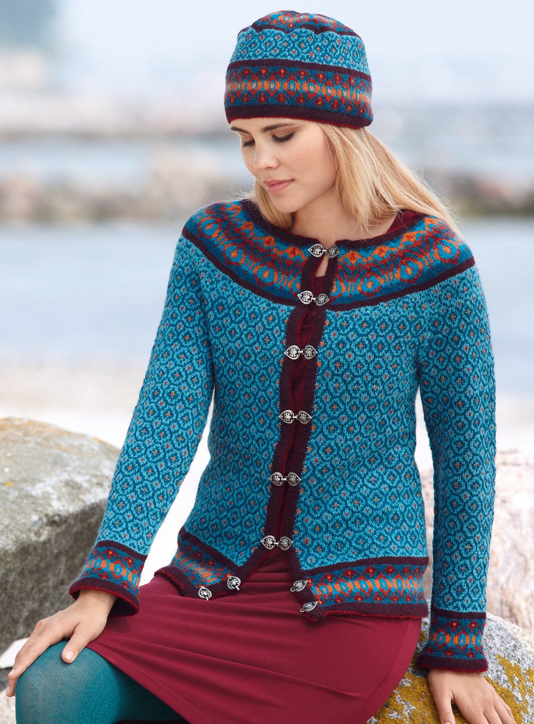Blauer Cardigan mit geometrischem Muster und Knöpfen. Passende Mütze. Farbkontrast modisch, handgefertigt.