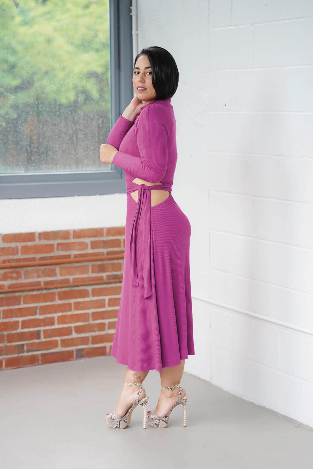 Lila Midi-Kleid mit raffiniertem Cut-Out, langärmelig, elegante Schleife, auffällige Farbauswahl, modische Akzente.