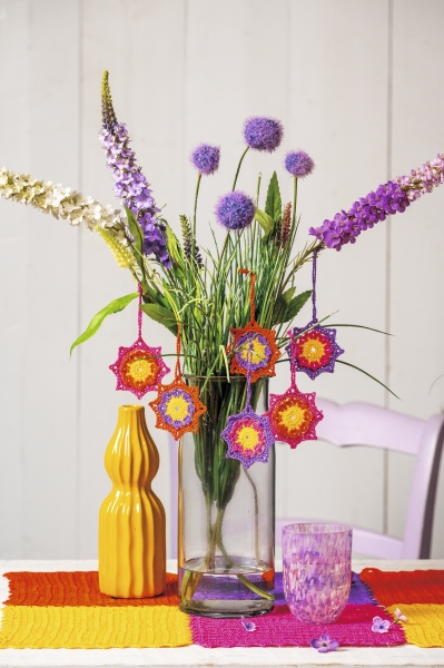 Handgemachte, gehäkelte bunte Sterne; kräftige Farben; DIY-Charme; dekorativ und kreativ.