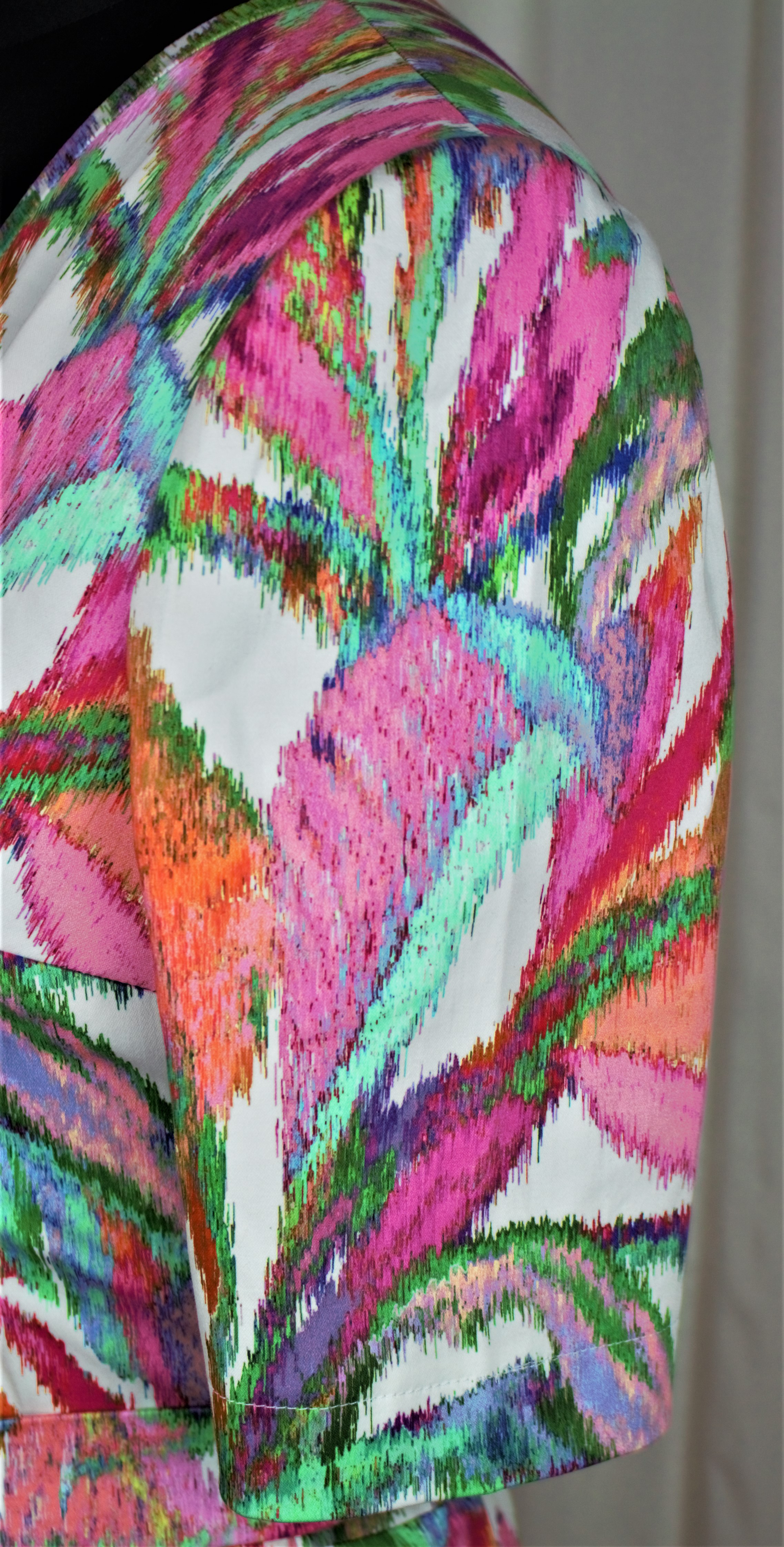 Kleidung mit lebendigem, abstraktem Muster in Pink, Grün und Orange. Modisch, handgemacht, kunstvolles Design.