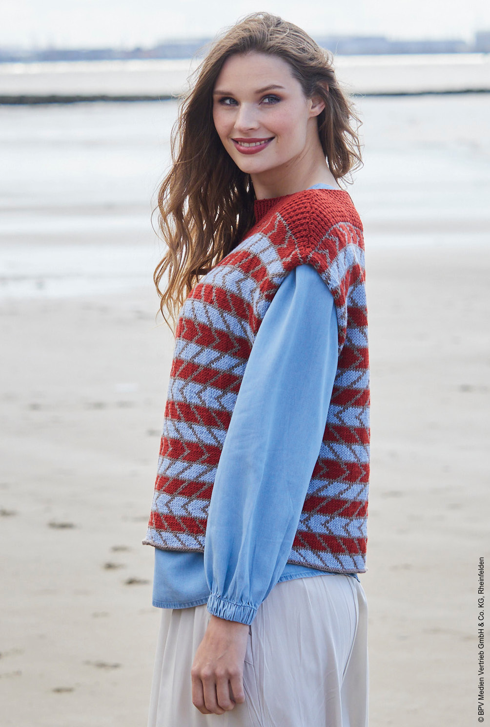 Modellansicht Bild 3: Oversize Pullunder im Jacquardmuster in Rot, Taupe und Hellblau