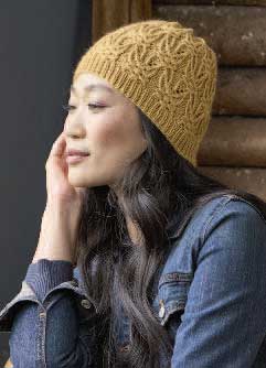 Senfgelbe Strickmütze mit Zopfmuster; handgemacht, modisch, detailverliebt. Kombiniert mit klassischer Jeansjacke.