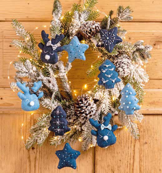 Deko-Kranz mit blauen, handgemachten Filzanhängern. Sterne und Hirsche, festliche Beleuchtung. Modisch, DIY.