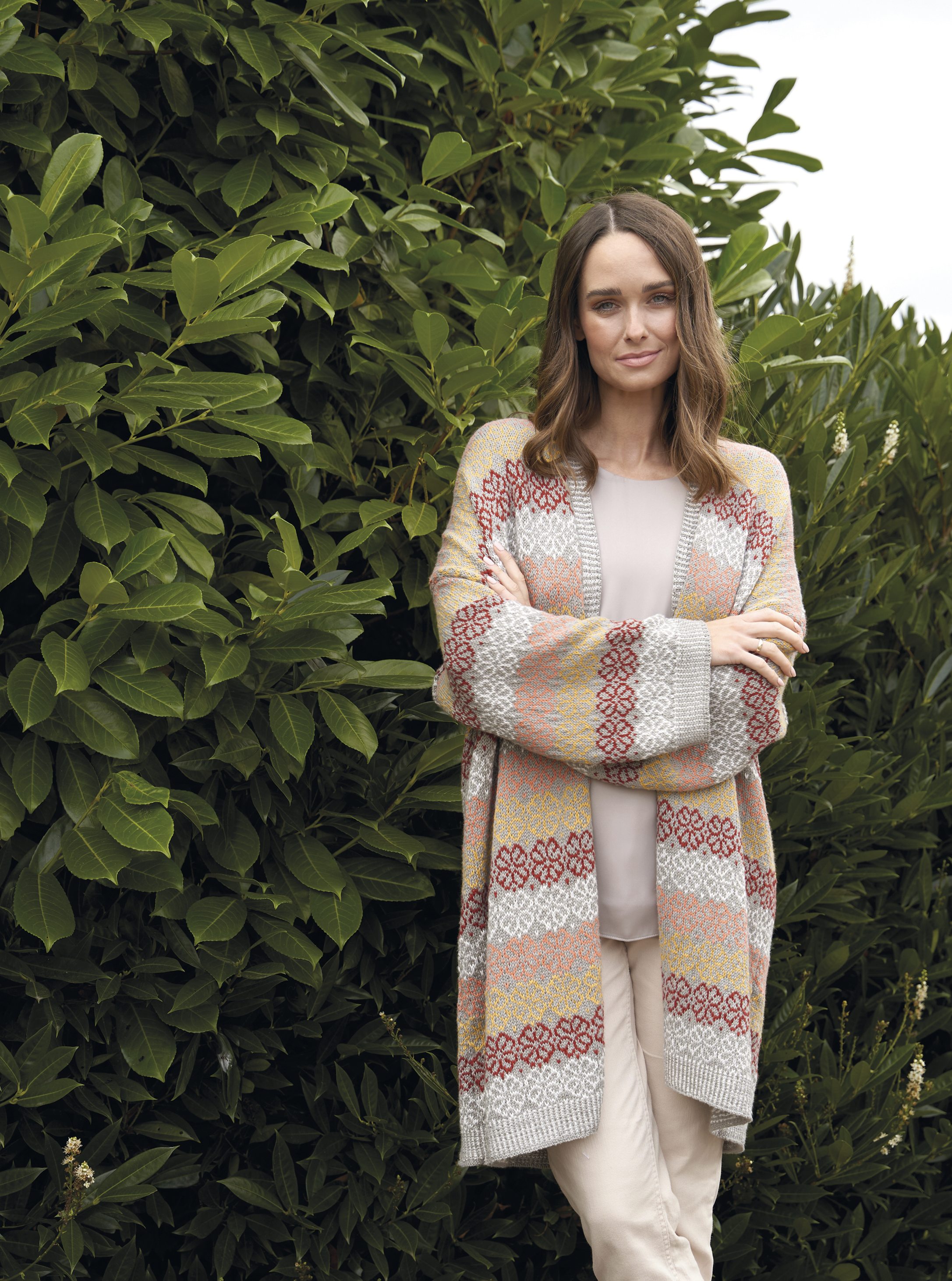 Pastellfarbener Cardigan mit gemusterten Streifen, modisch und handgemacht wirkend.
