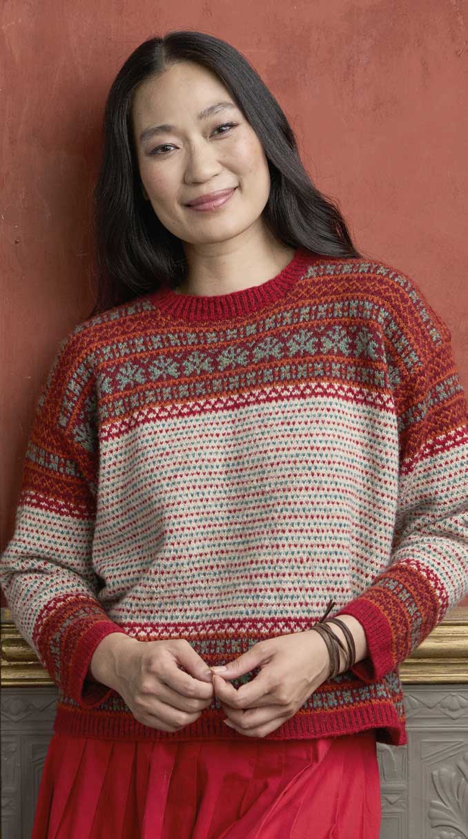 Modischer Norweger-Pullover in Rot und Grau, handgemacht, detailreiche Muster, klassischer Schnitt.