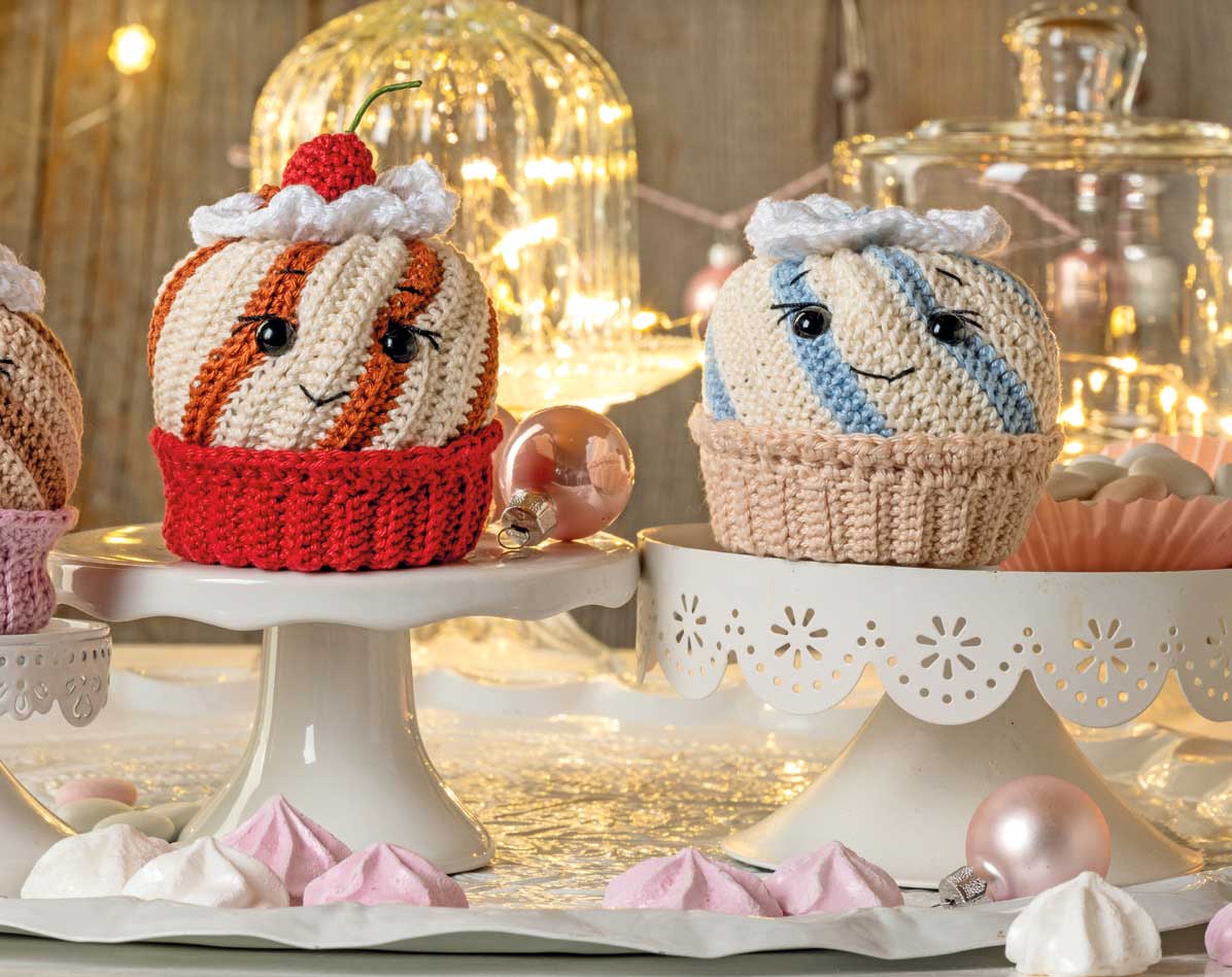 Modische, selbstgemachte Häkel-Cupcakes. Rot-weiße Streifen, adrette Gesichter; Beige-blaues Design. Handarbeit, DIY.