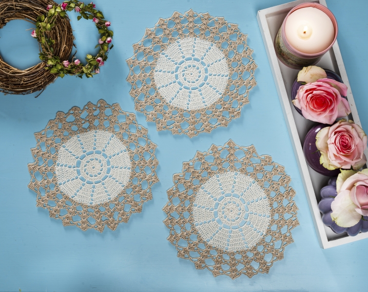 Handgemachte, runde Häkeldeckchen; beige-weiß, feines Muster, kunstvolle Handarbeit, modisches Design.