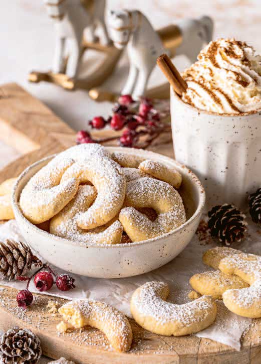 Frische, handgemachte Vanillekipferl, mit Puderzucker bestäubt. Rustikaler Charme in heller Keramikschale.