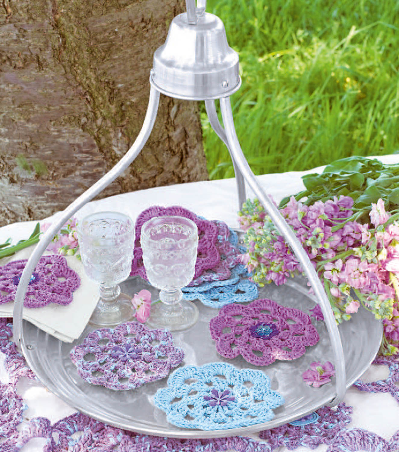 Farbenfrohe, selbstgemachte Häkeldeckchen auf Tablett; floral, modisch, DIY, kunstvoll.