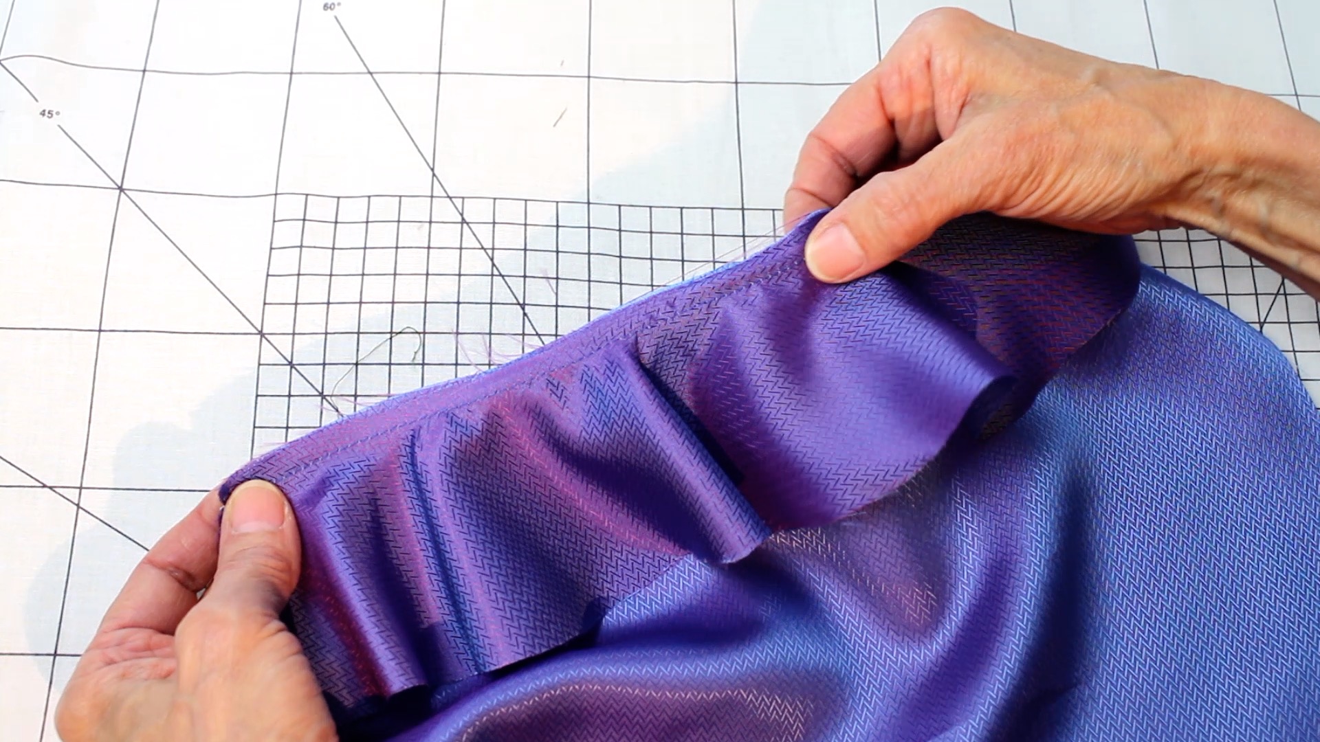 Satin mit violettem Schimmer, Zickzackmuster, handgemacht; fließende Eleganz, modischer Stil.