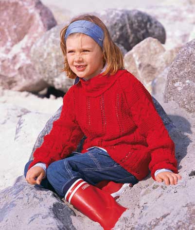 Leuchtender, handgestrickter roter Pullover, kombiniert mit Jeans und roten Gummistiefeln. Modisch und handgemacht.