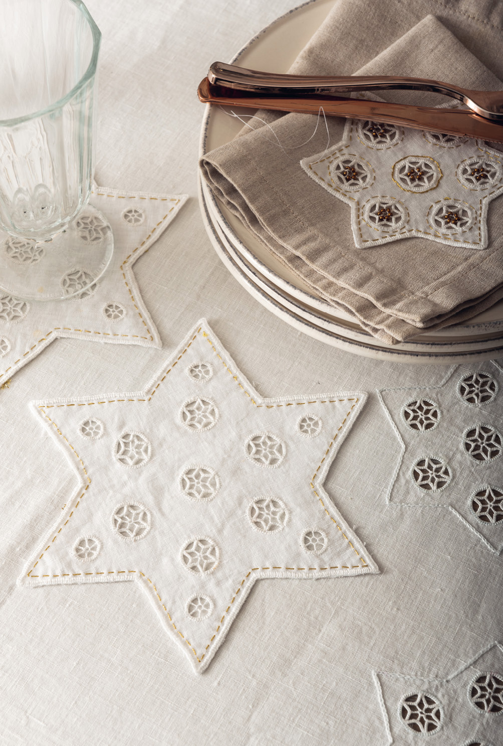 Modellansicht Bild 7: Mit Sternen bestickte Tischdecke, Sternenuntersetzer und -anhänger sowie Stulpen