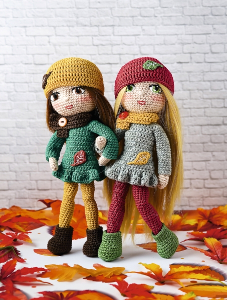 Farbenfrohe, handgemachte Puppen mit gestrickten Kleidern, Mützen; herbstliche Akzente, moderne DIY-Ästhetik.