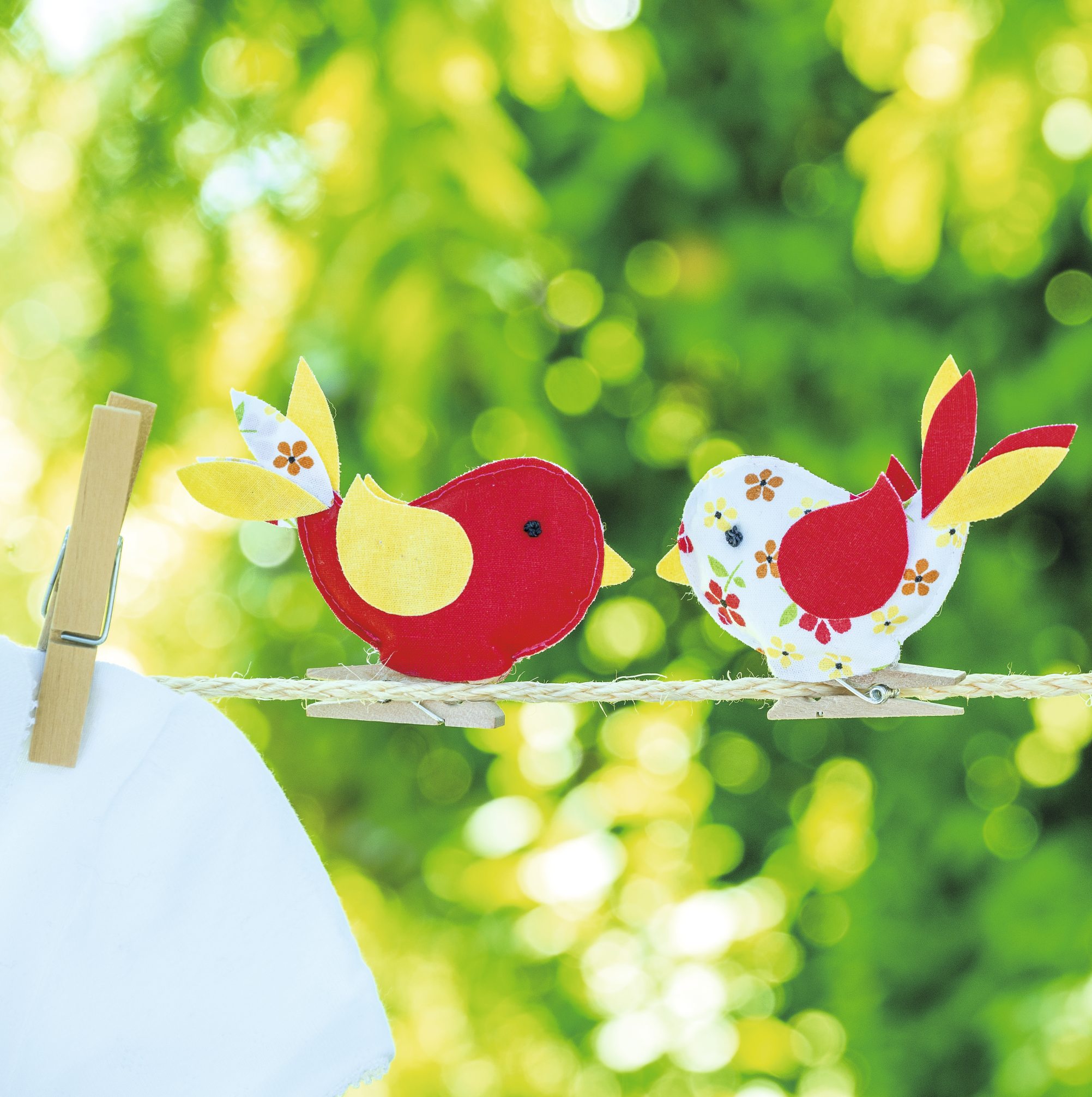 Zwei handgemachte Stoffvögel in Rot und Weiß mit Blumenmuster. Modisch und kreativ gestaltet.