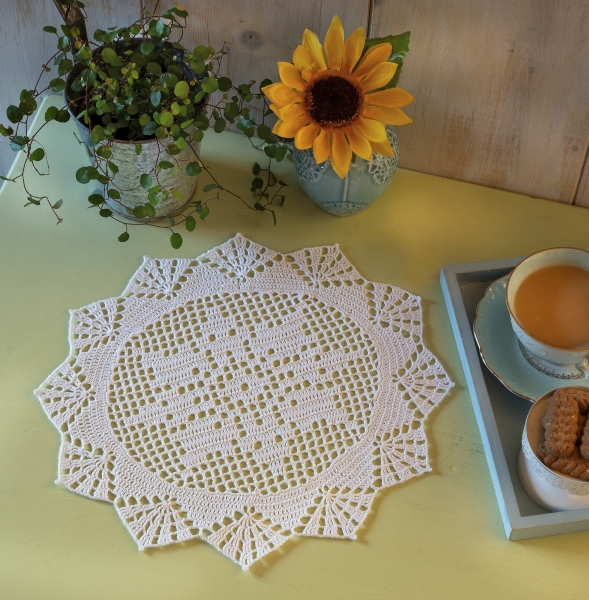 Weiße, filigrane Häkelarbeit mit sternförmigem Muster, selbstgemacht und detailverliebt.