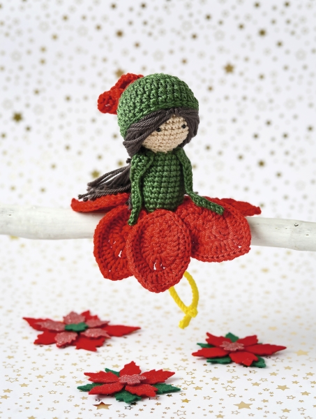 Handgefertigte Puppe in rot-grünem Outfit mit gehäkeltem Muster, süßes DIY-Design. Modischer Winterlook.