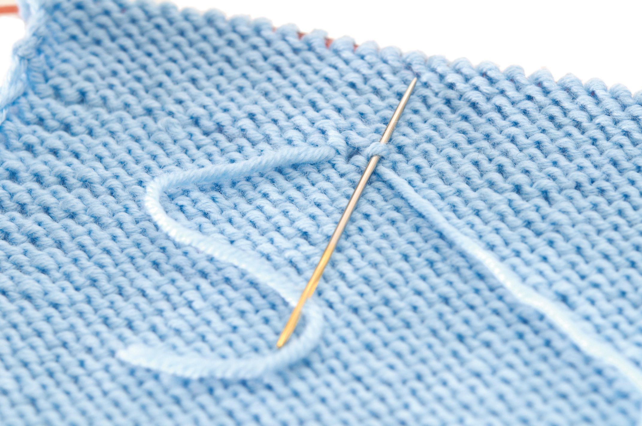 Hellblaues Strickmuster, handgemacht, DIY-Stil, zarte Maschen, einfache Eleganz, kreative Handarbeit.