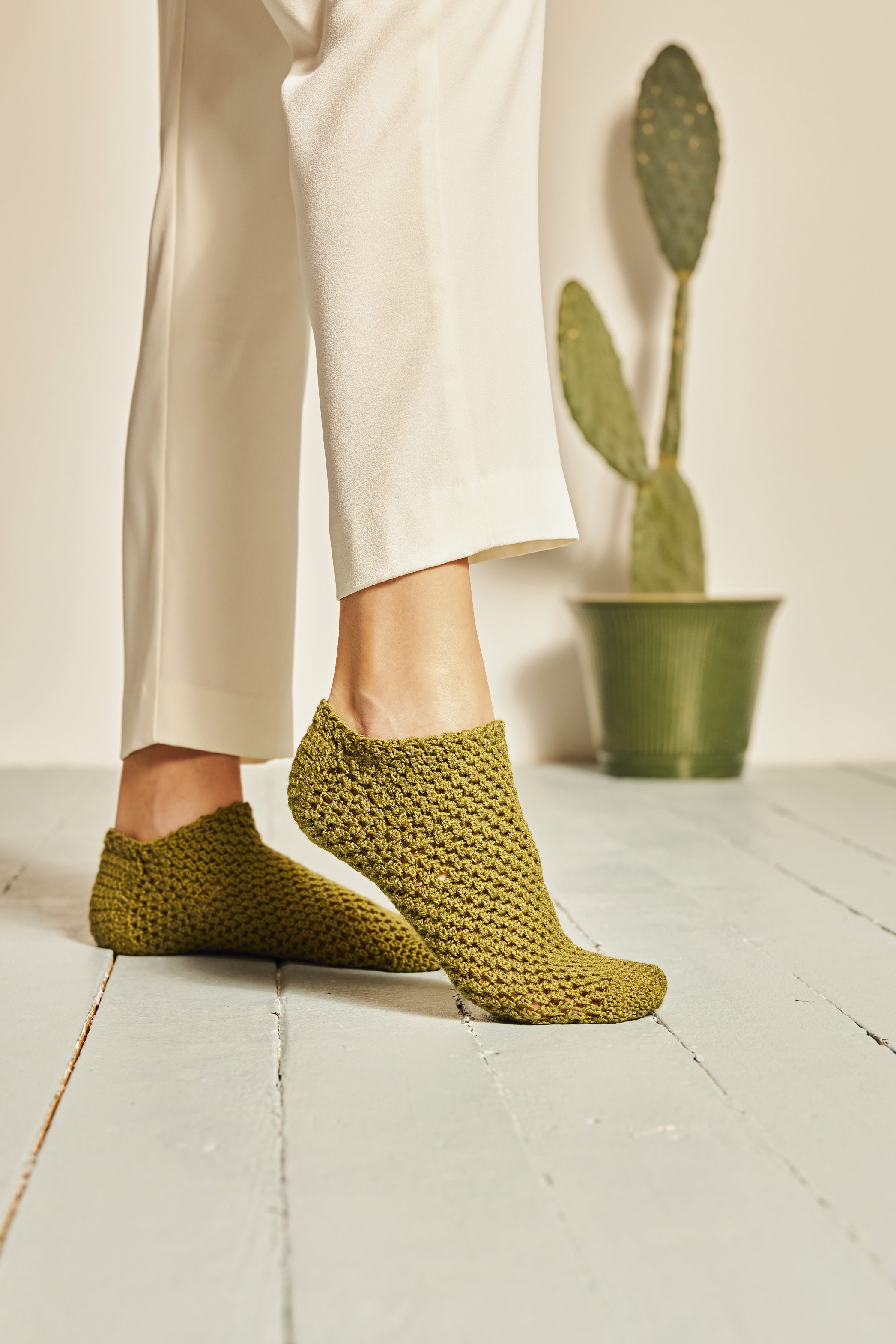 Olivgrüne, handgemachte Stricksocken, modisch und bequem. Elegante Struktur, perfekt zu weißen Hosen.