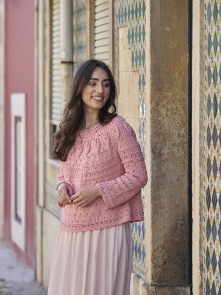 Rosa Pullover mit Strickmuster, modisch und handgemacht. Lange Ärmel, Detailreich, elegant kombiniert mit einem Rock.