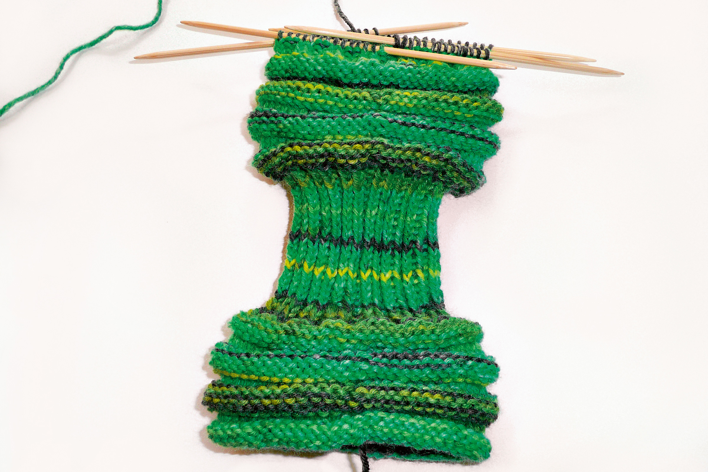 Handgemachter, grüner Schal mit Streifenmuster und Rippstrick, modisch und DIY.