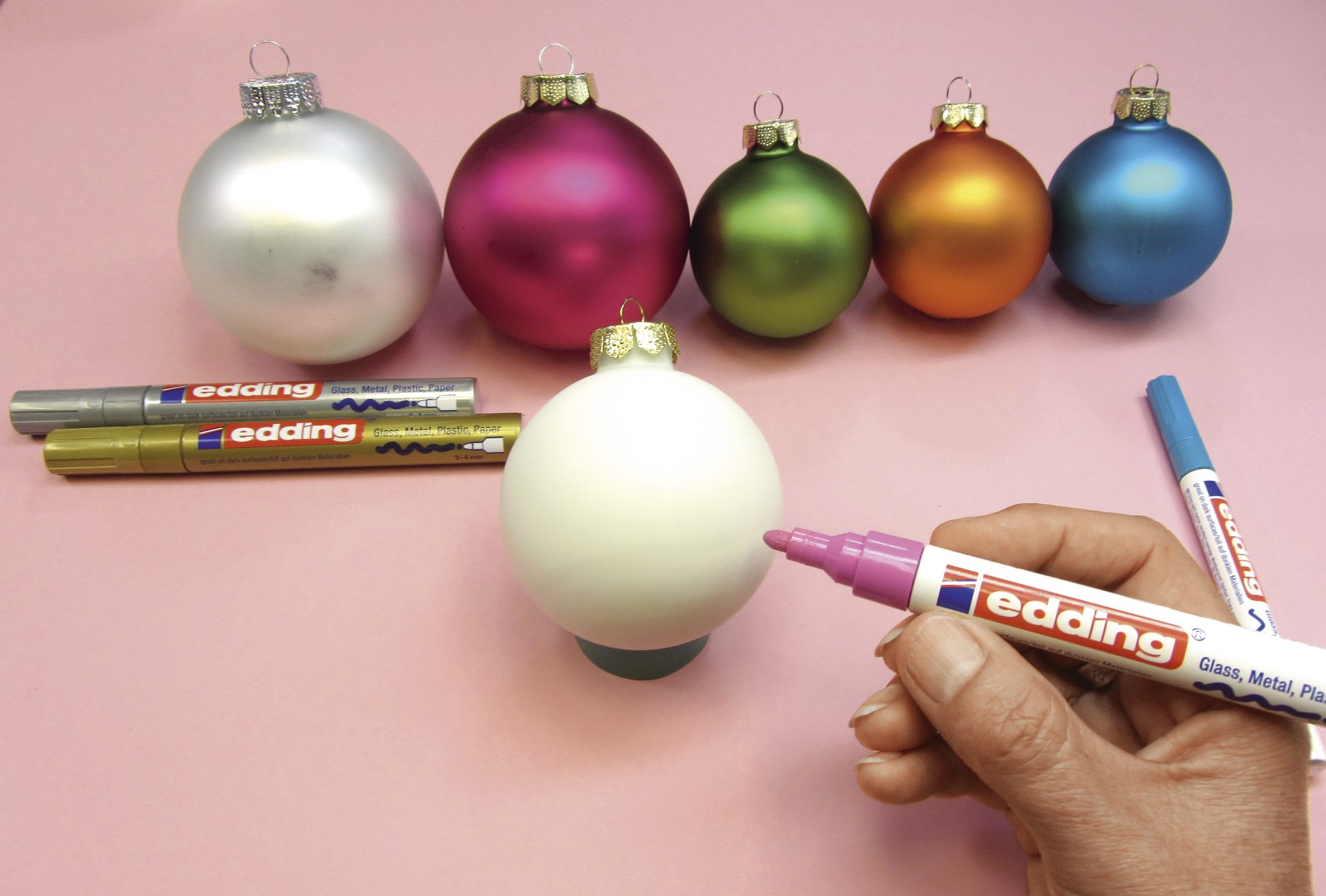 Selbstgemachte Deko: Bunte Weihnachtsbaumkugeln mit Edding-Stiften kreativ verziert. Handarbeit, glänzend, individuell.