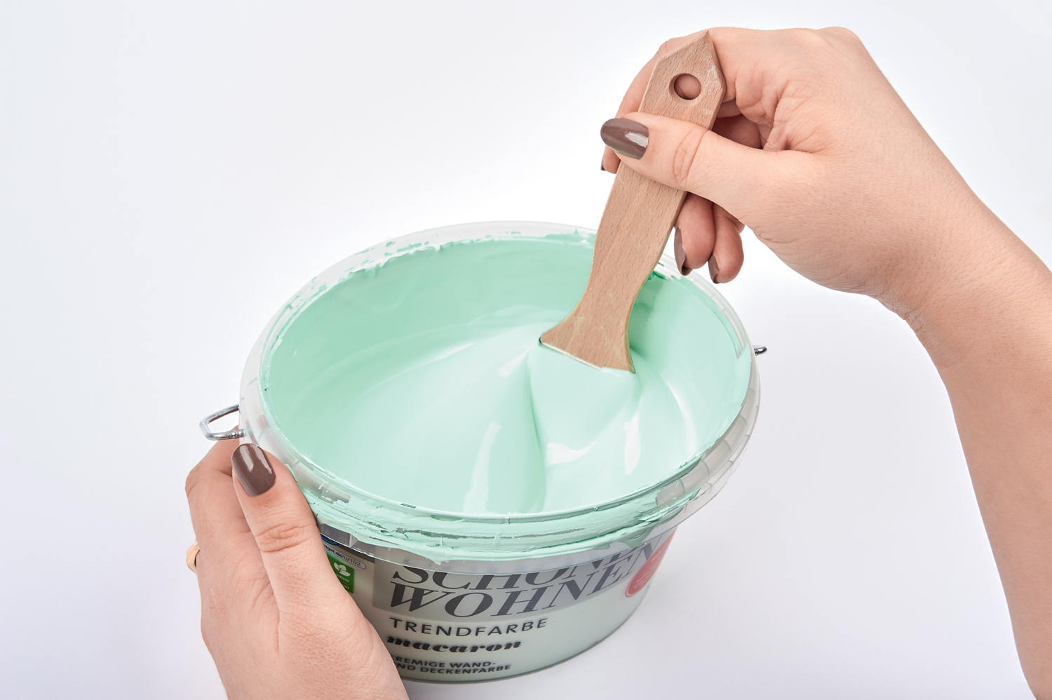 Hand mit pastellmintfarbenem Pullover, modisch und handgemacht, weiche Farbtöne, DIY-Charme.