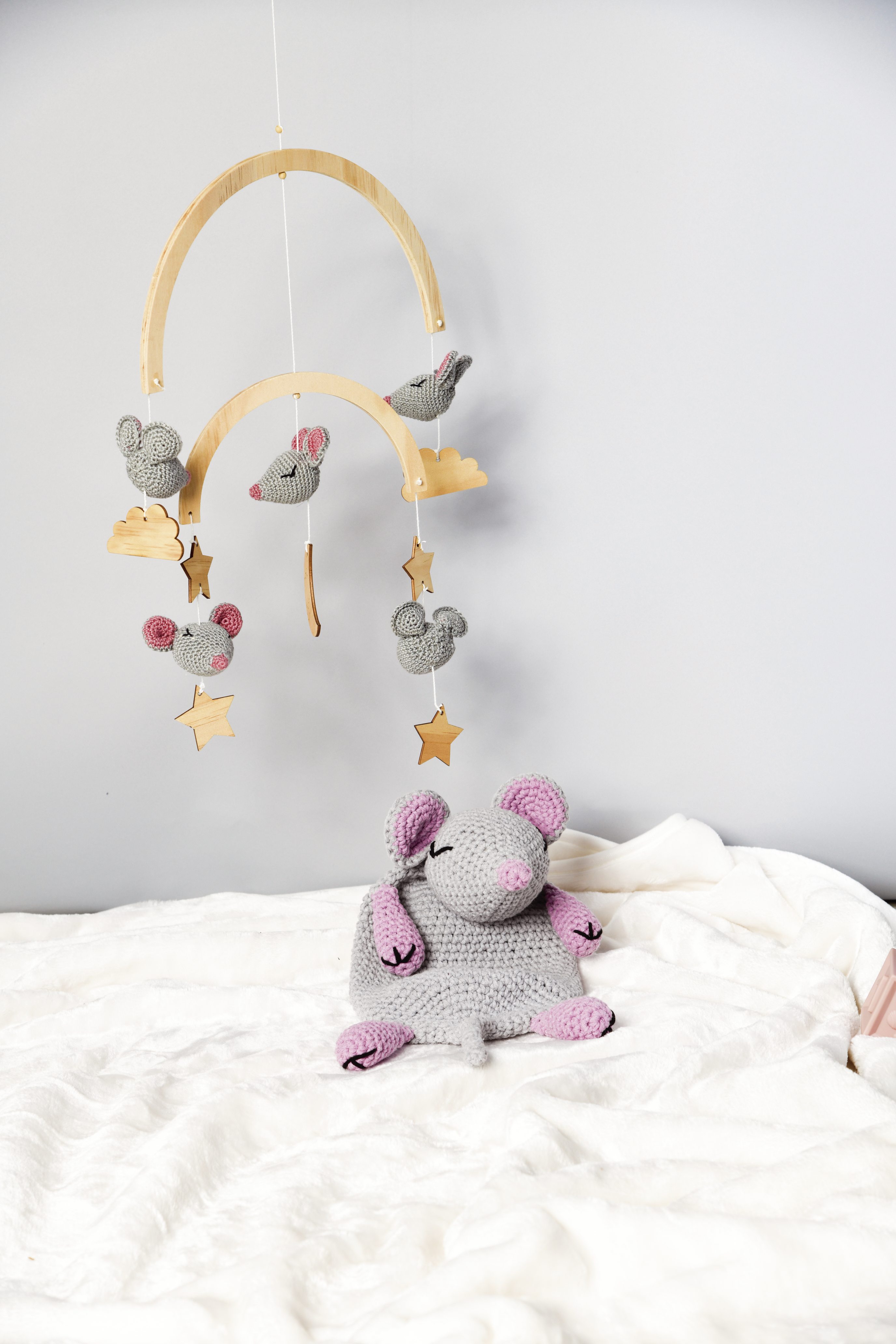 Grau-rosa gehäkelte Maus mit Wolken-Mobile. Handgemacht, sanfte Pastellfarben, liebevolle Details. DIY Flair.