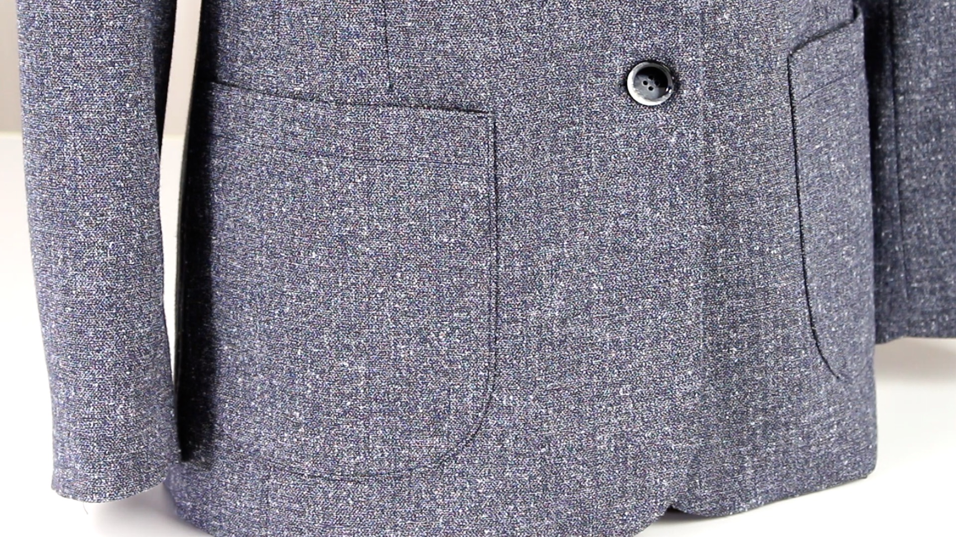 Grauer Tweed-Blazer, texturiertes Muster, klassischer Schnitt, stilvolle Knopfleiste, modisch und zeitlos.
