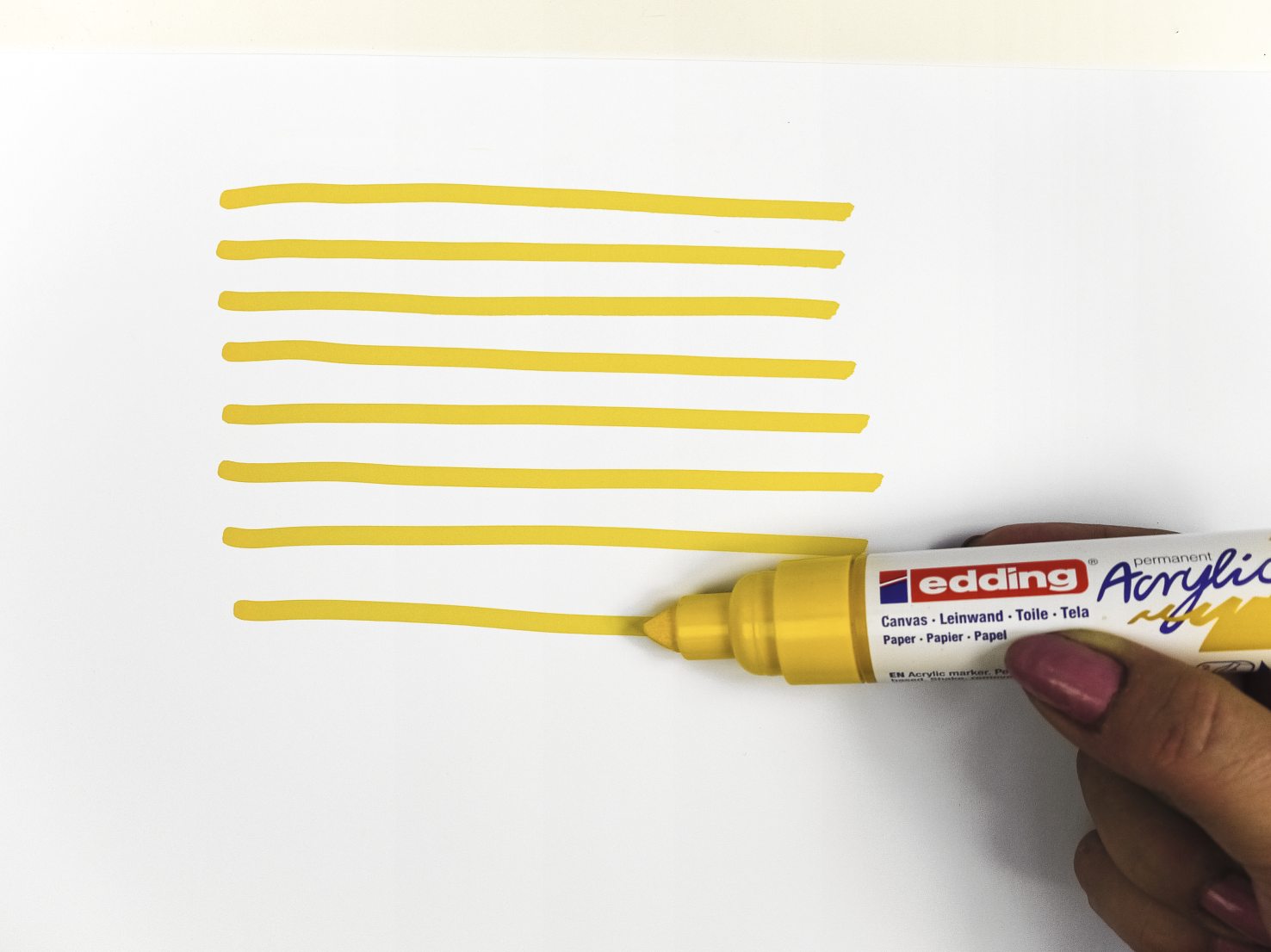 Acht gelbe, parallele Linien, gezogen mit einem dicken, gelben Acrylmarker. Kreativ und kunstvoll.
