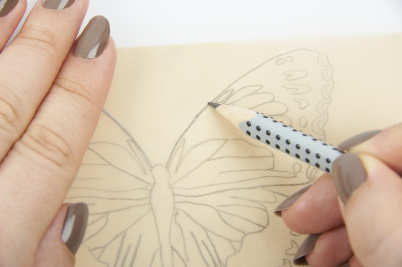 Gepunkteter Bleistift, taupefarbige Nägel, detailreiche Schmetterlingszeichnung, präzise Handarbeit.