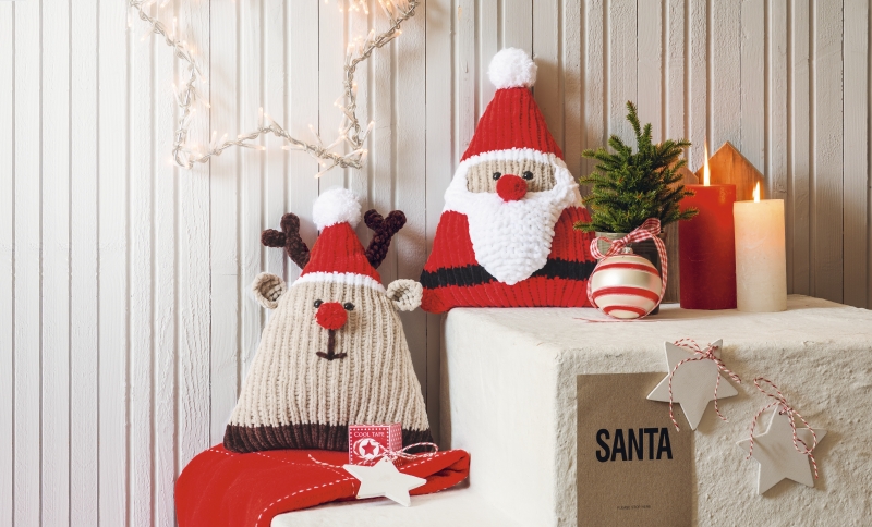 Handgestrickte Kissen in Rot, Weiß, Beige. Niedliches Rentier- und Santa-Muster, DIY-Charme, festliches Design.